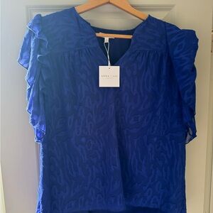 Blue ruffled flutter sleeve blouse with cap sleeves and a boxy fit